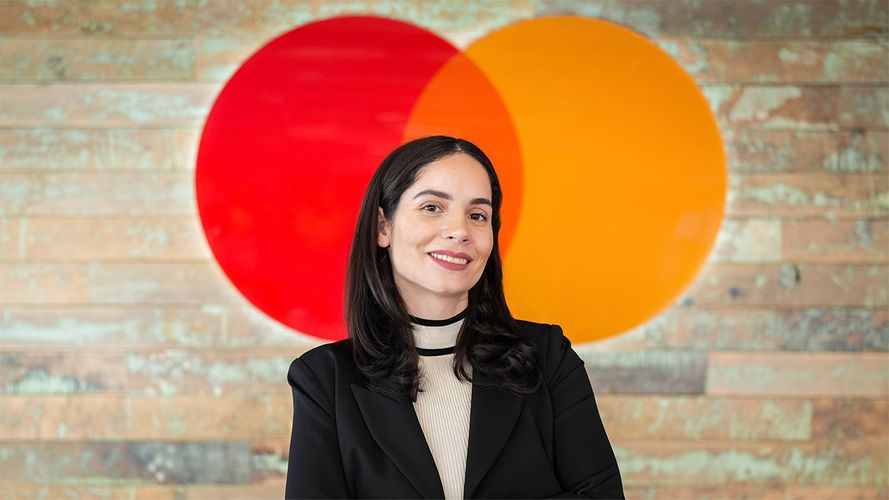 Indhira Jaquez-Torres Mastercard headshot posing in front of logo