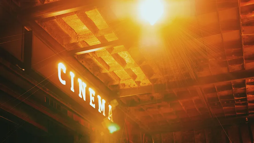 An illuminated sign on the exterior of a movie theater that says Cinema