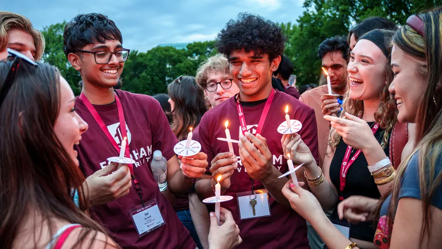 New students hold candles at the candle lighting ceremony during new student orientation