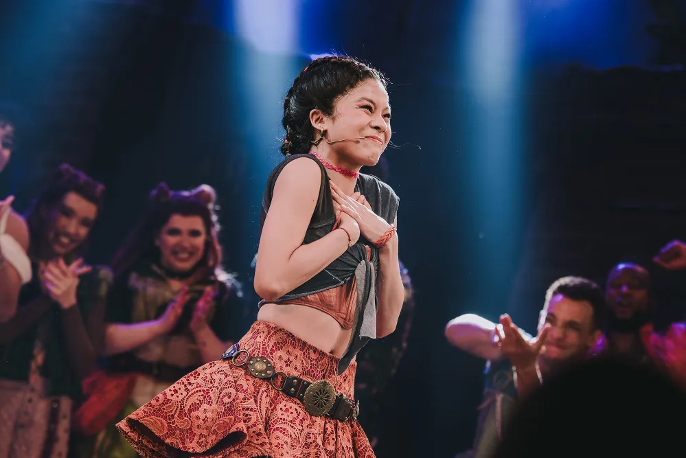 A student smiling on stage ad she performs