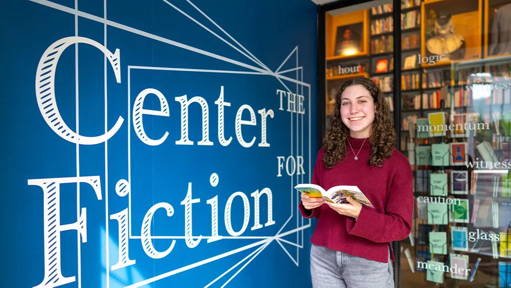 Madison Cossaboom standing in front of Center for Fiction signage