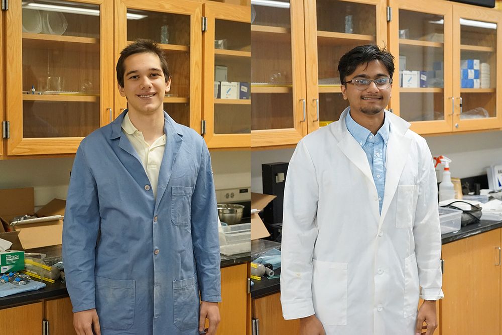 Two students pose in a lab