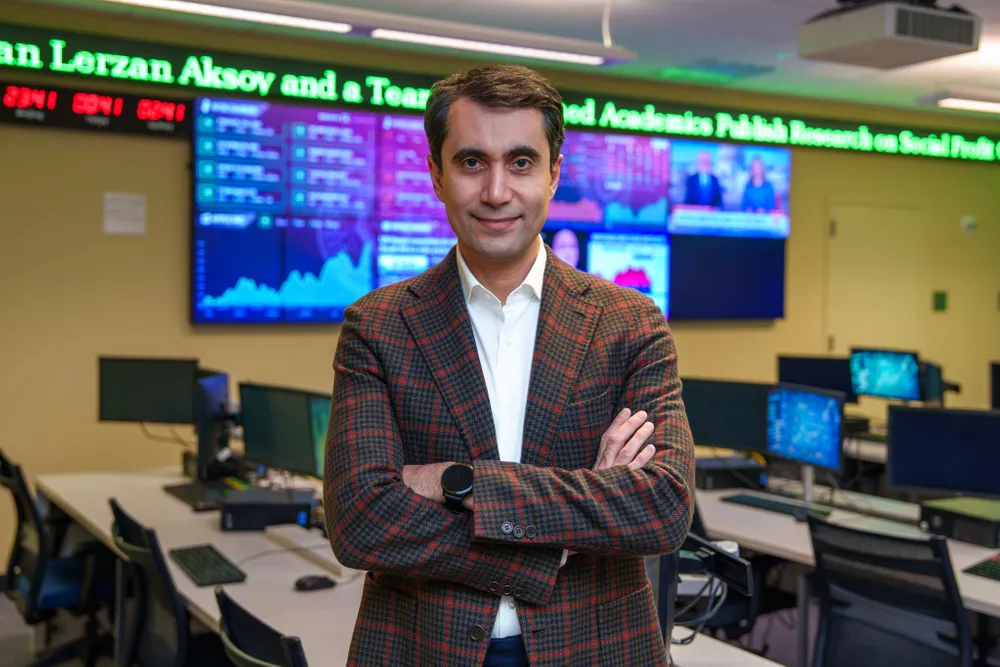 Navid Asgari standing in the Gabelli trading room at the Lincoln Center campus