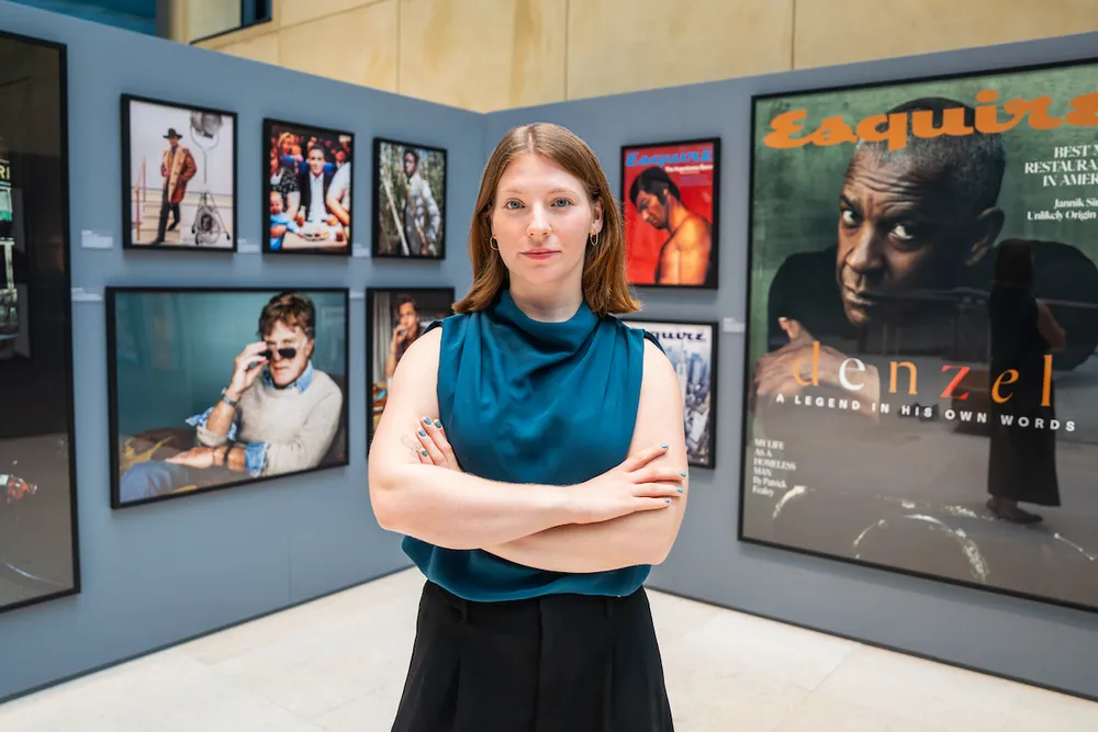 Carley Walker stands in front of an Esquire magazine gallery wall
