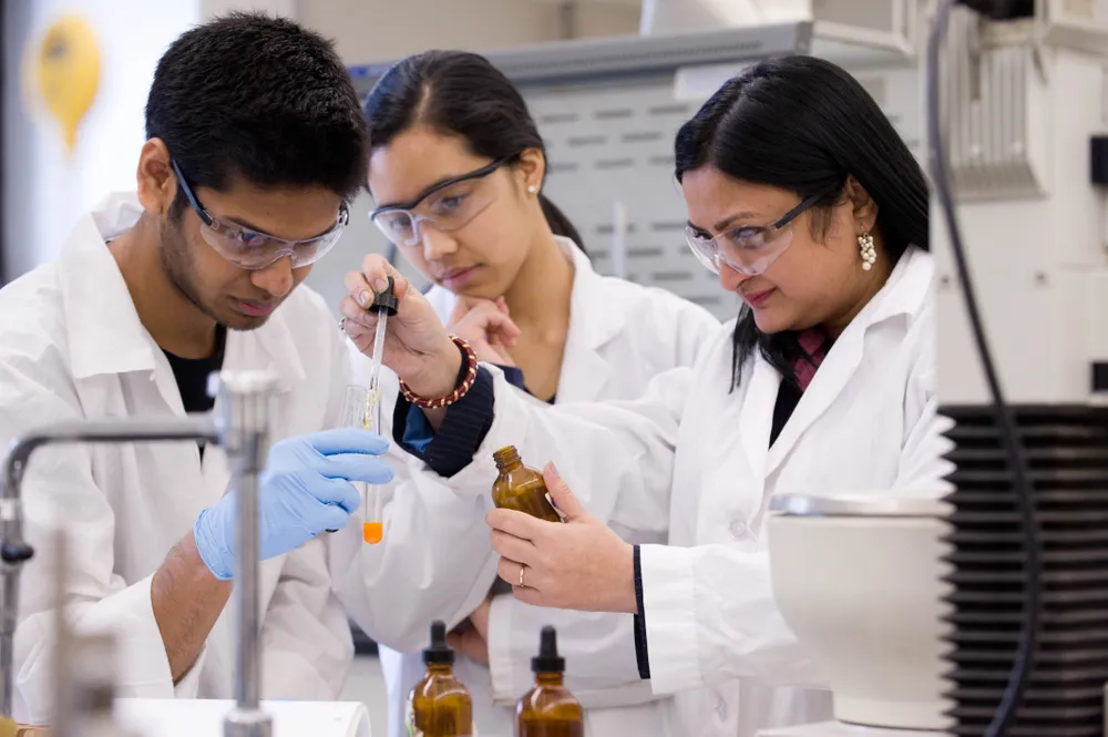 Three science students working in a lab setting.