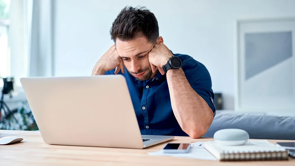 A distressed-looking man at his computer, illustrating the theme of people seeking empathy from AI platforms online