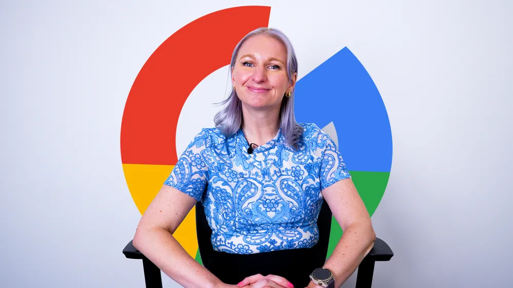 Maggie Senft sitting in a director's chair with the Google logo behind her