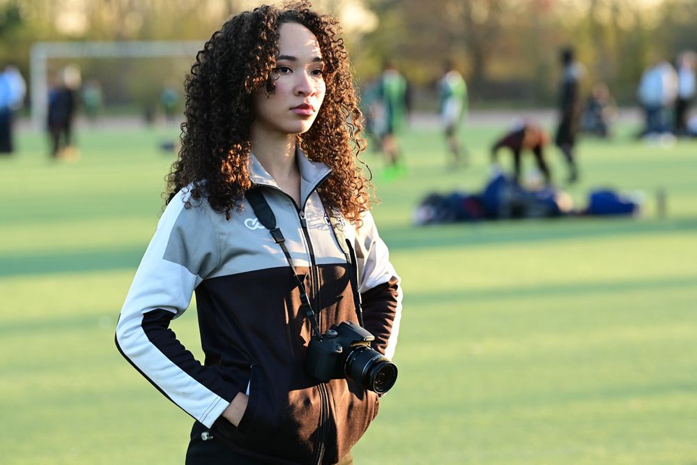 Licha Gonzalez poses with a camera at internship with City Schools Sports Association.