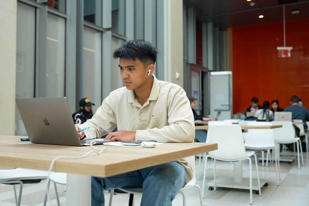 A male student studies at a table in the gallery of the McShane Center