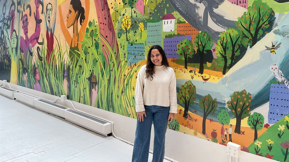 Maria Jose Salume poses in front of a mural at the Climate Museum in NYC.