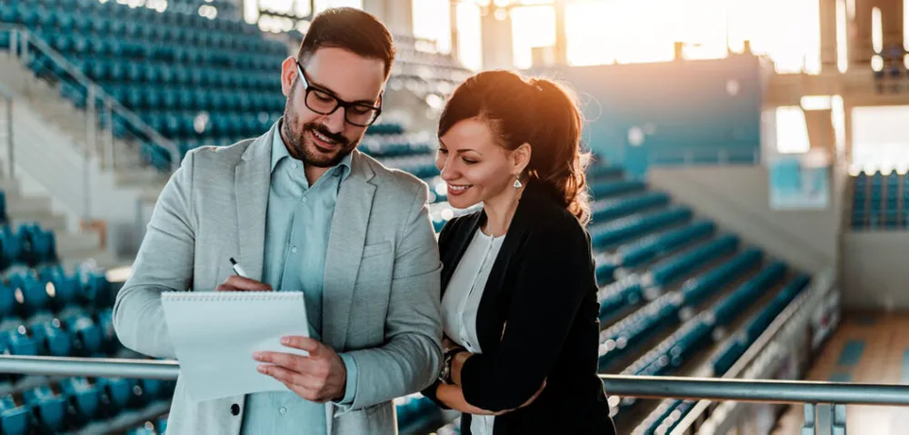 Two students collaborating in a sport complex