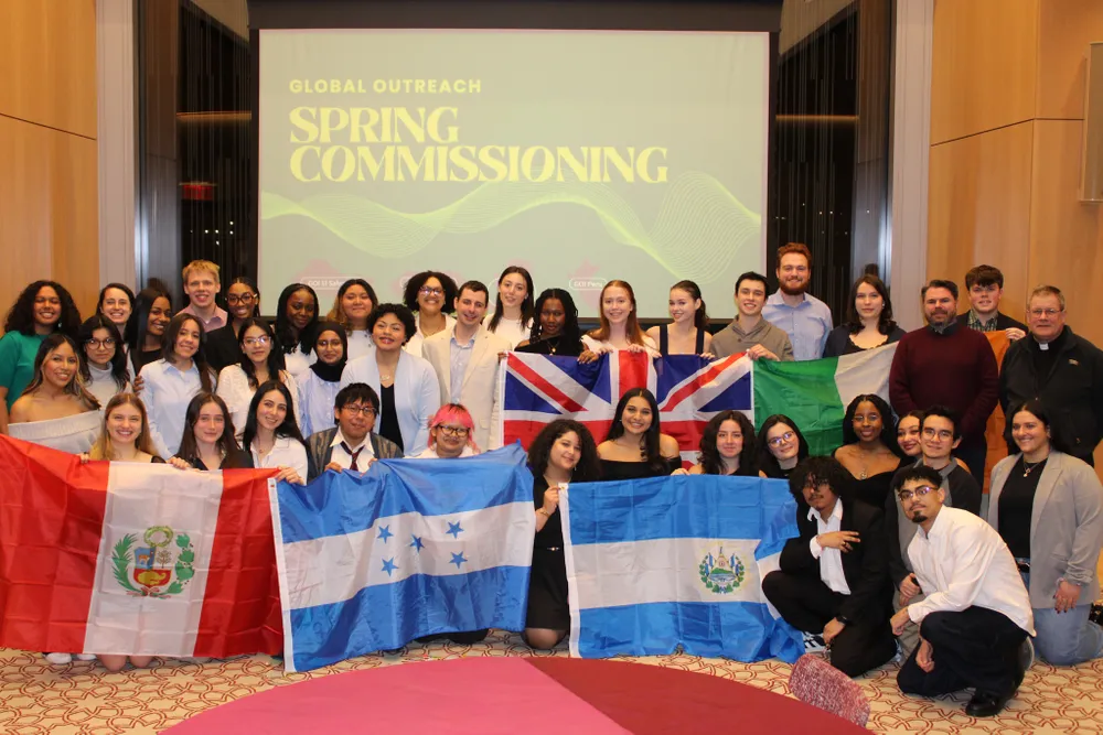 Groups of GO teams pose with their countries' flags at GO Commissioning