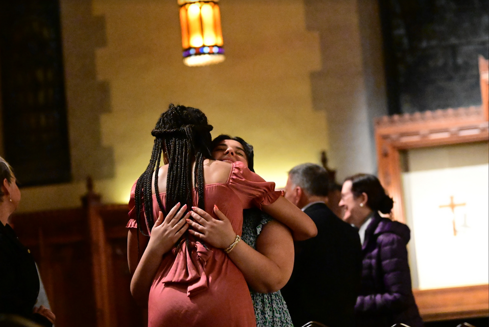 Two students hugging during the giving of peace at Mass at the University Church.
