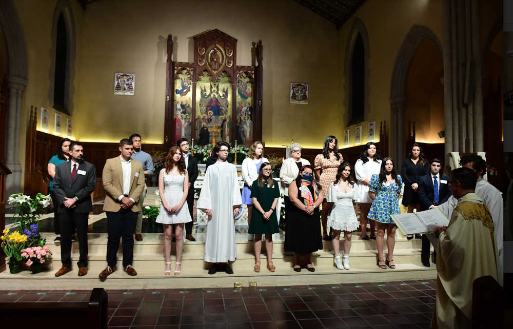 Candidates for sacraments standing in a group in front of the University Church in front of the Altar.