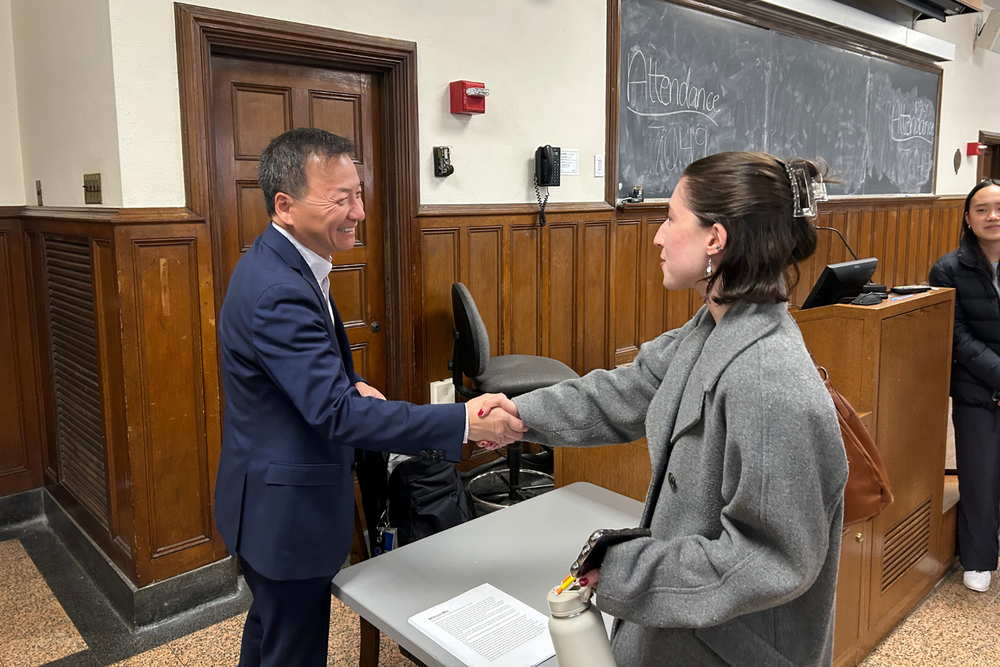 President's Council member shaking hands with a student after presenting to a group of pre-law students