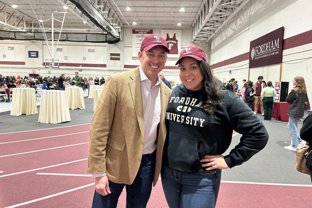 President's Council members posing in Fordham gear at an admitted student day in the Lombardi Field House