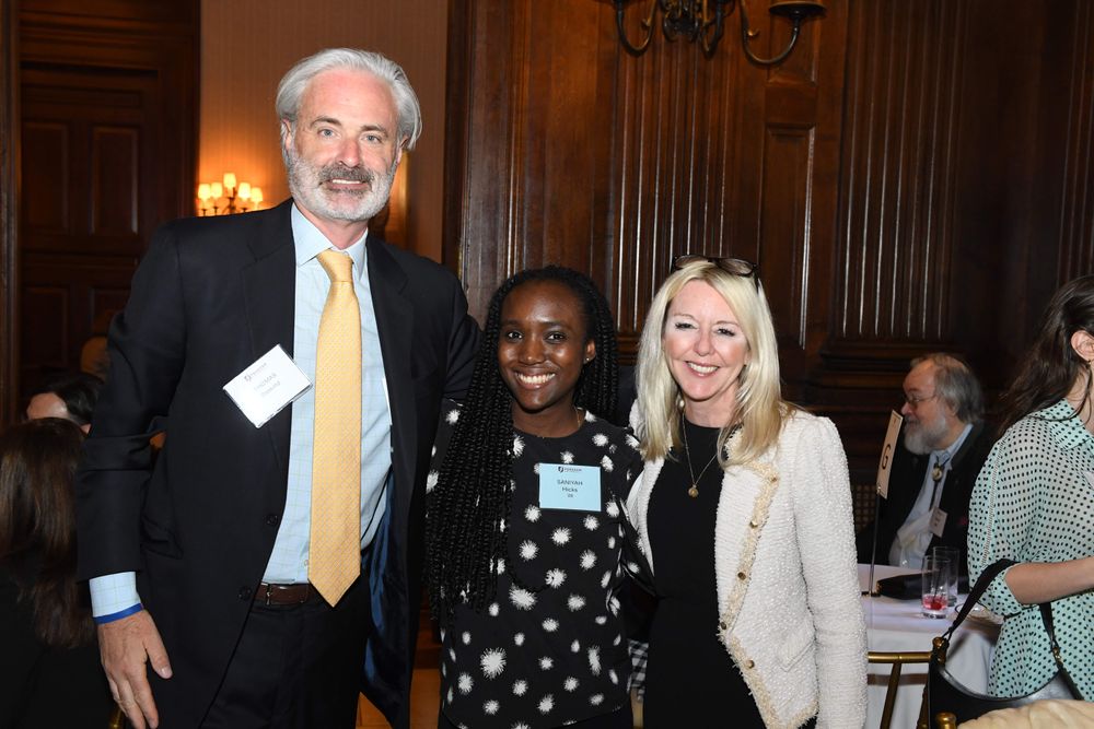 male donor and guest stand on either side of female student