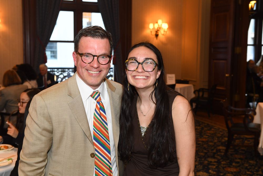male donor with glasses standing with smiling female student