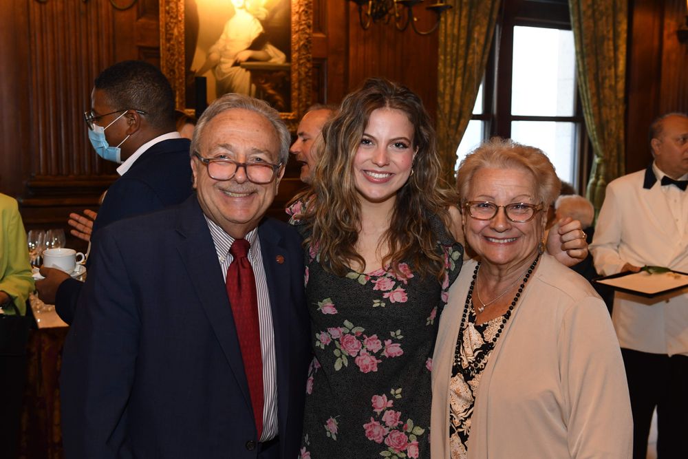smiling female scholarship recipient with male and female scholarship donors standing on either side