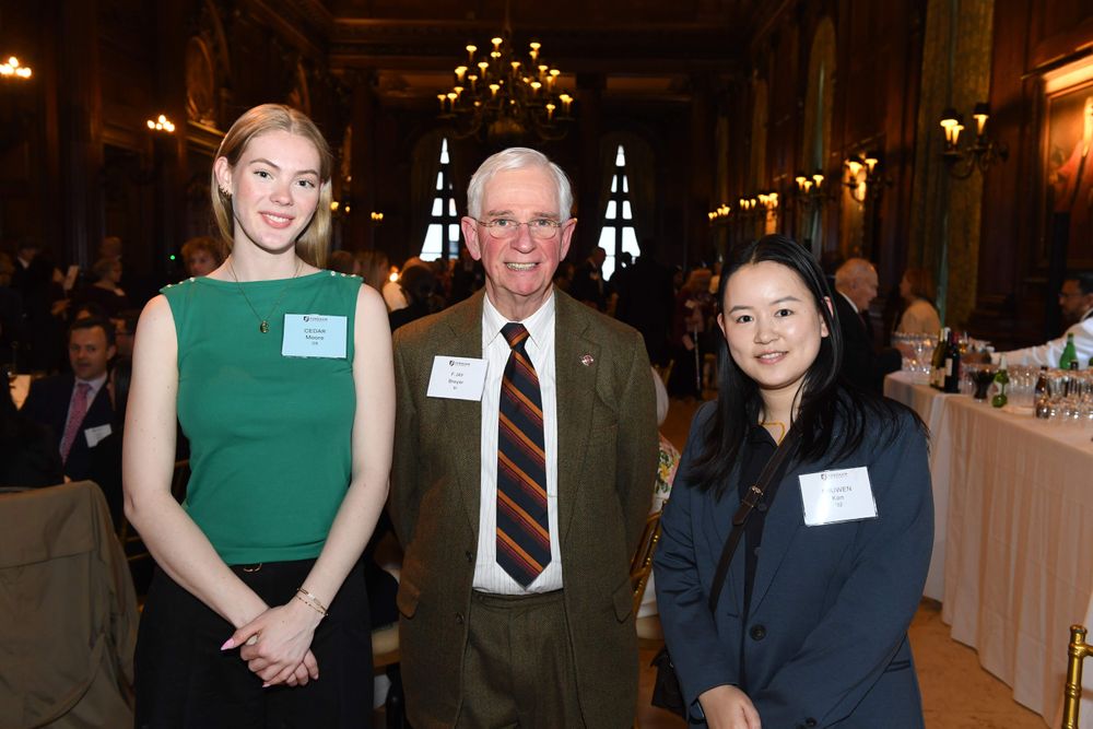 two female students stand on either side of male donor
