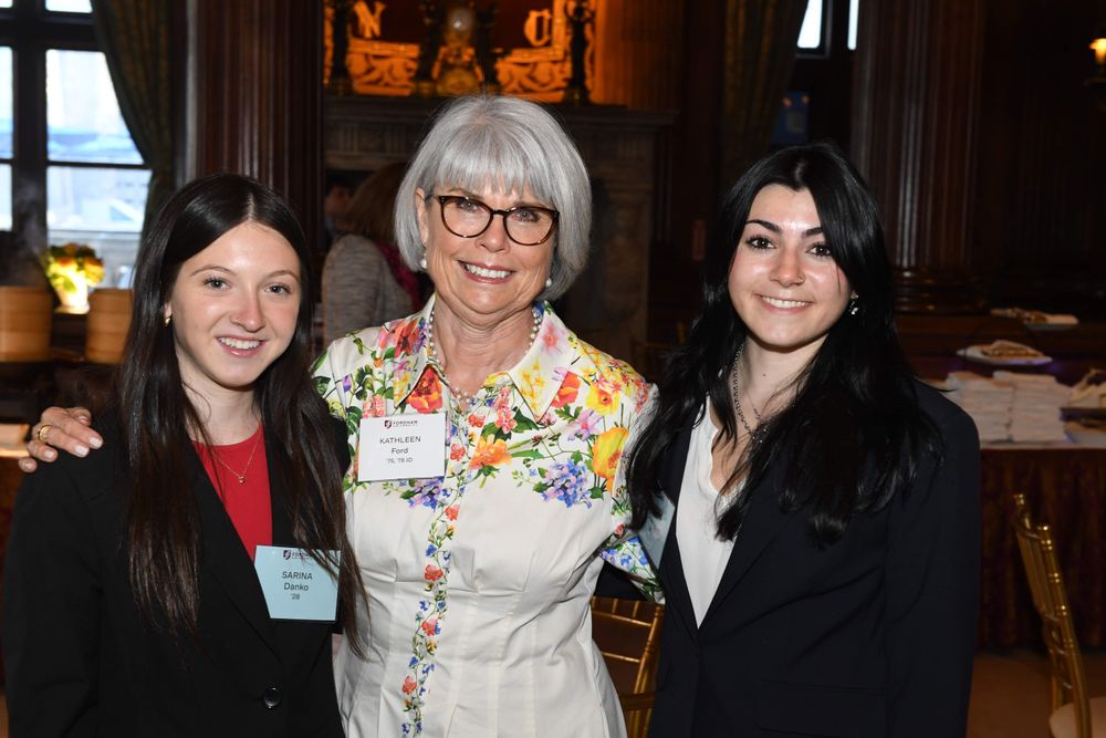 two female students stand on either side of female donor