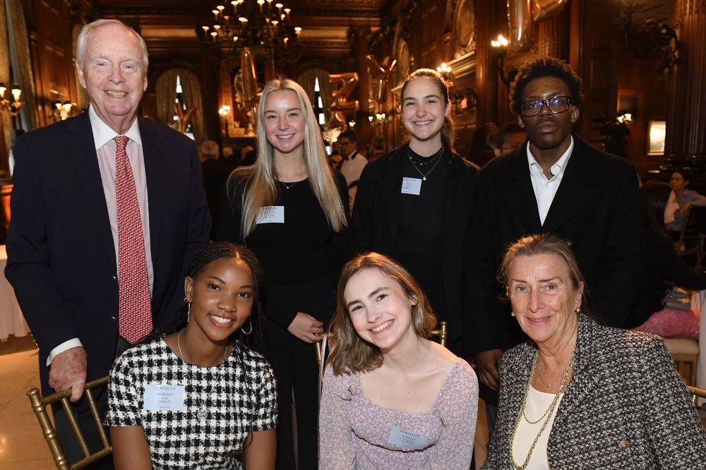 An older male donor and female donor pose with four female students and one male student at the Scholarship Donors and Recipients Reception