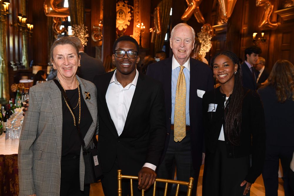 female and male donor standing with two scholars
