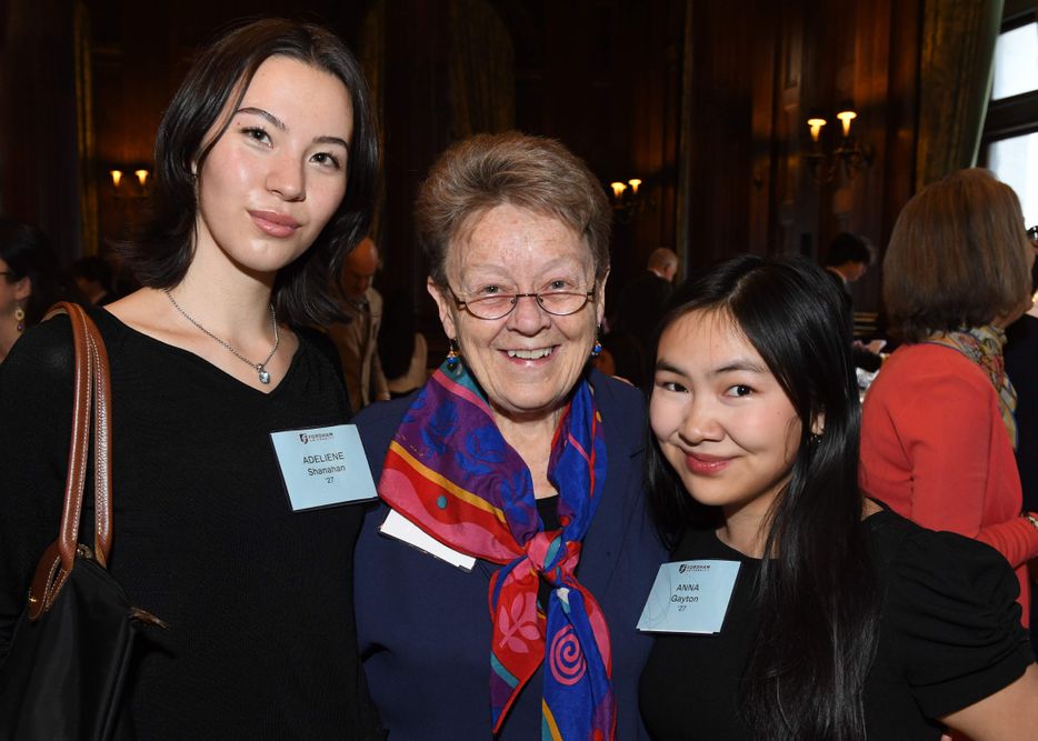 two female students stand on either side of female donor