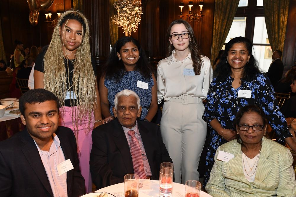 Three female and two male donors stand with two female students at the Scholarship Donors and Recipients Reception