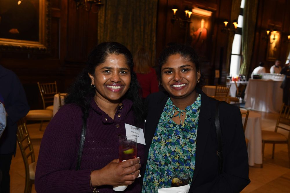 two female donors stand smiling