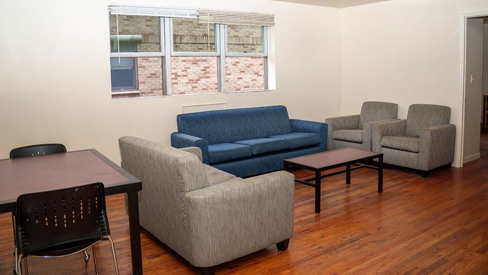 Common space with table, sofa, lounge chairs and a coffee table.