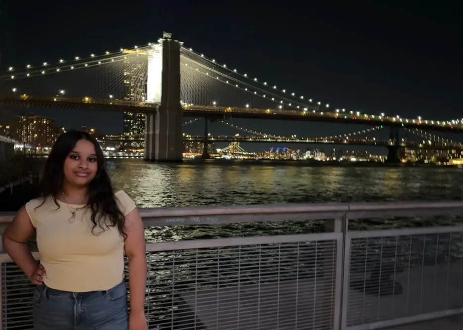 A Student standing out side in the night in front of a landscape