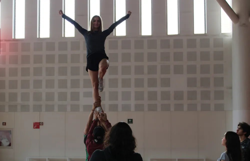 Student being held up in a cheerleading pose