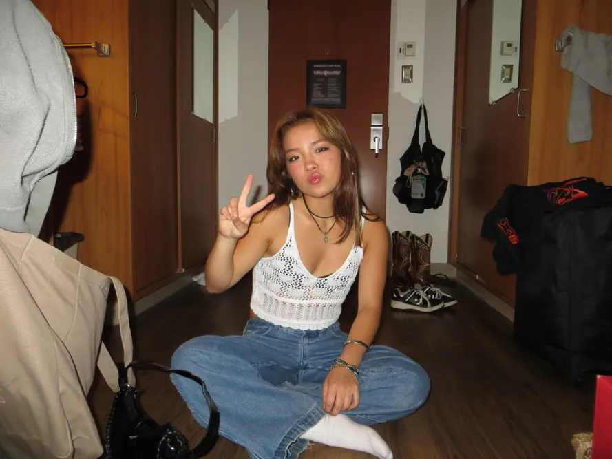 A student sitting on the floor of a dorm room