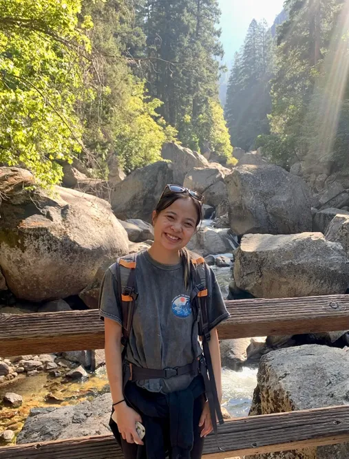 Natalie is standing in front of a naturescape