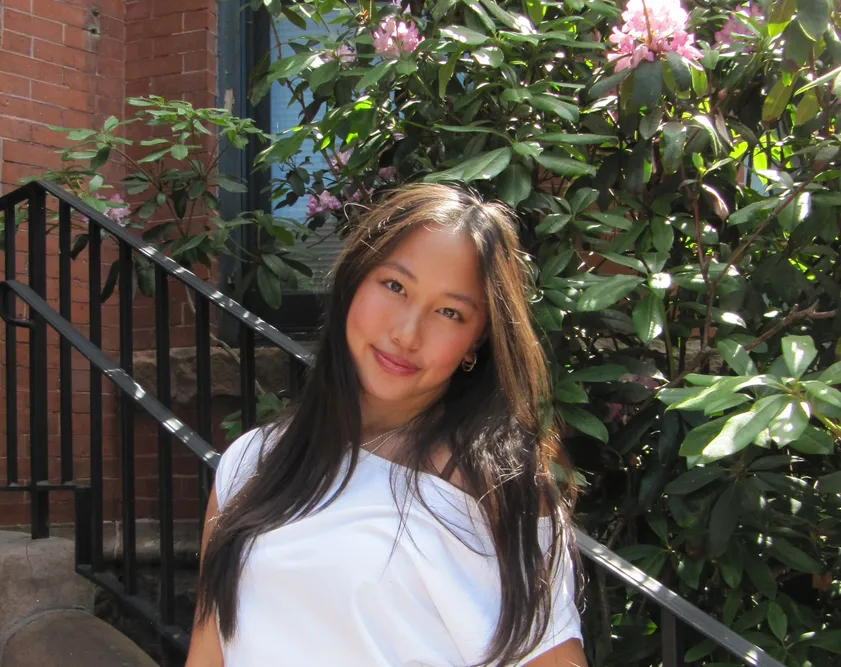 Student standing in front of plant