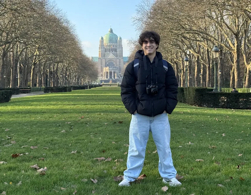 Trey standing in a park with a building in the distance