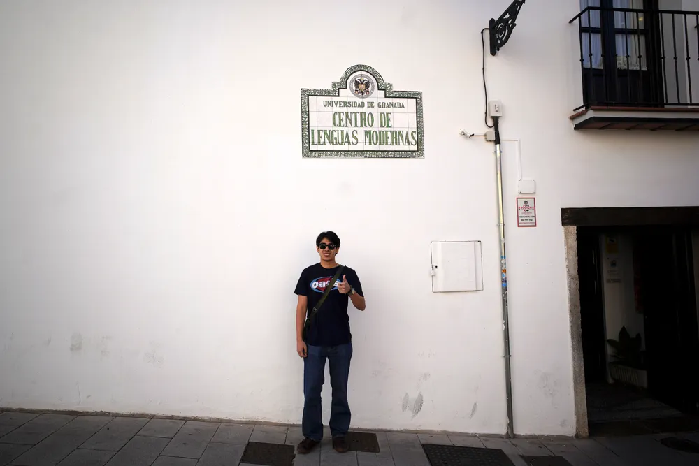Nico standing in the sidewalk under a Universidad de Granada sign