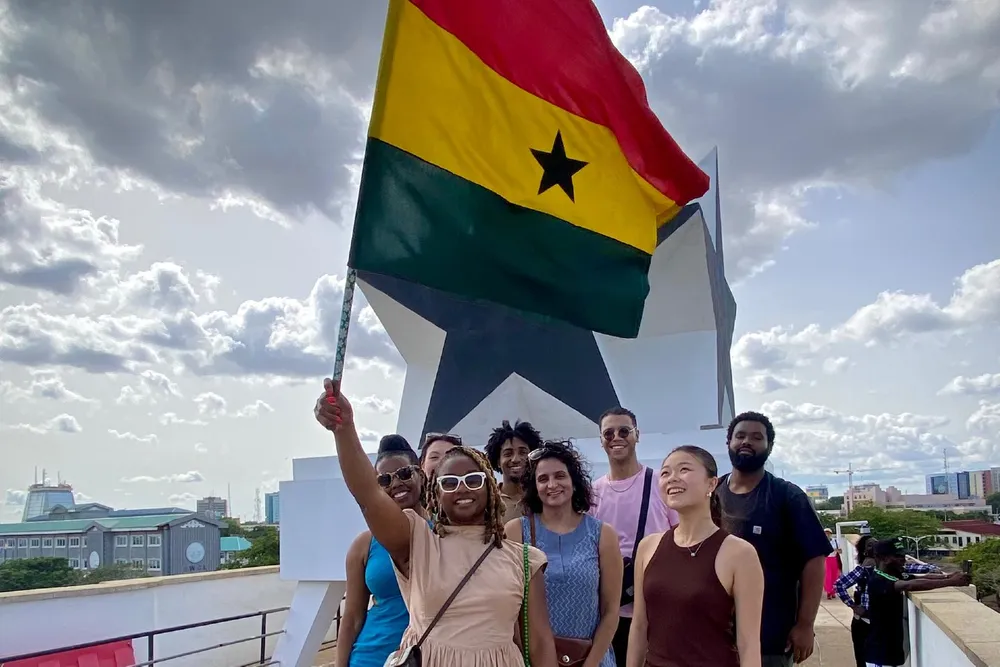 students and staff at the Black Start Gate with a Ghana flag