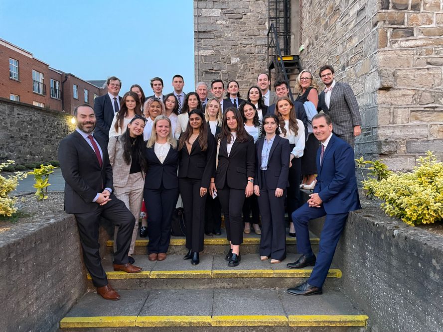 Fordham Law Ireland summer program 2023 students wearing suits in front of stone building