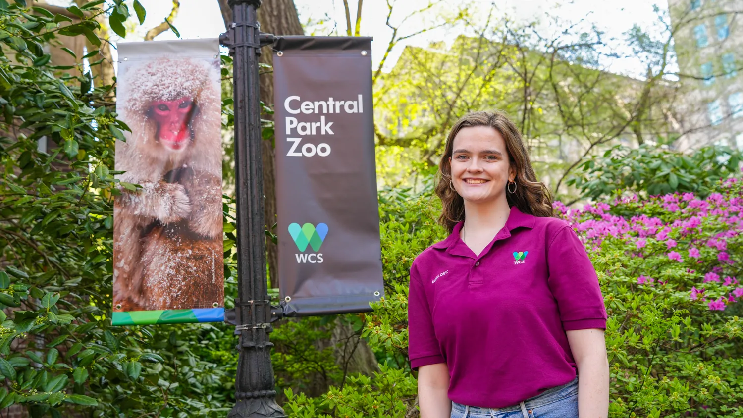 Shannon standing next to a Central Park Zoo/monkey sign