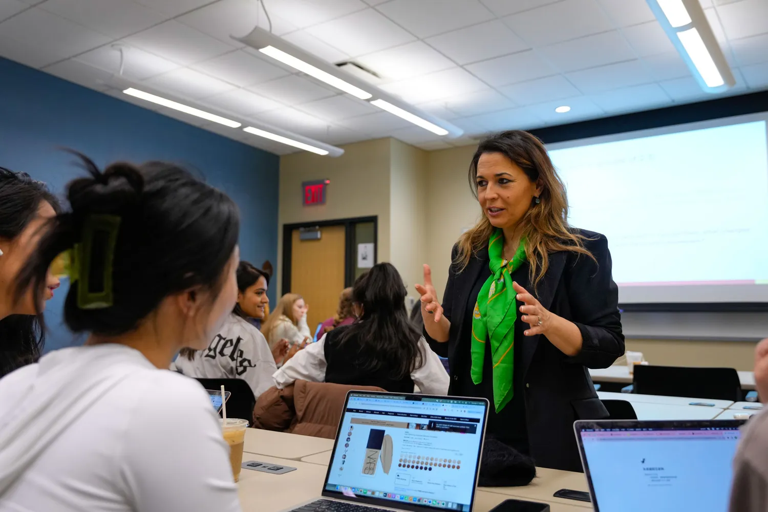 A business school professor talks with her students in class