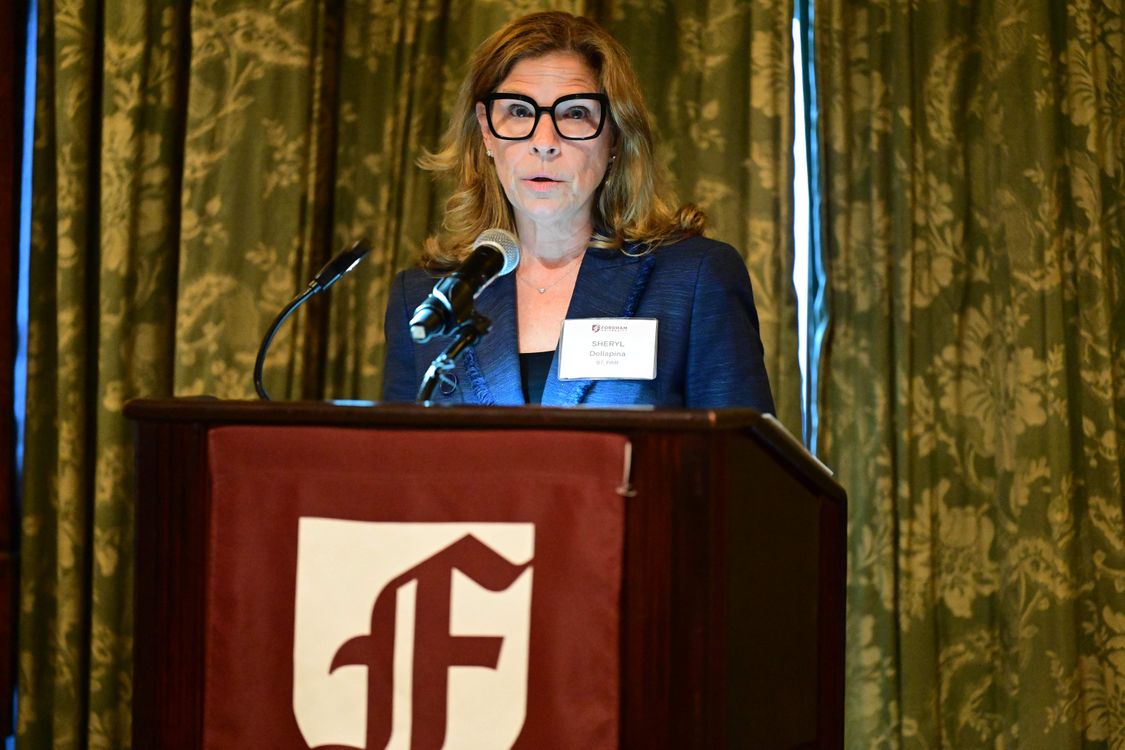 Fordham Trustee, Sheryl Dellapina, speaking at podium