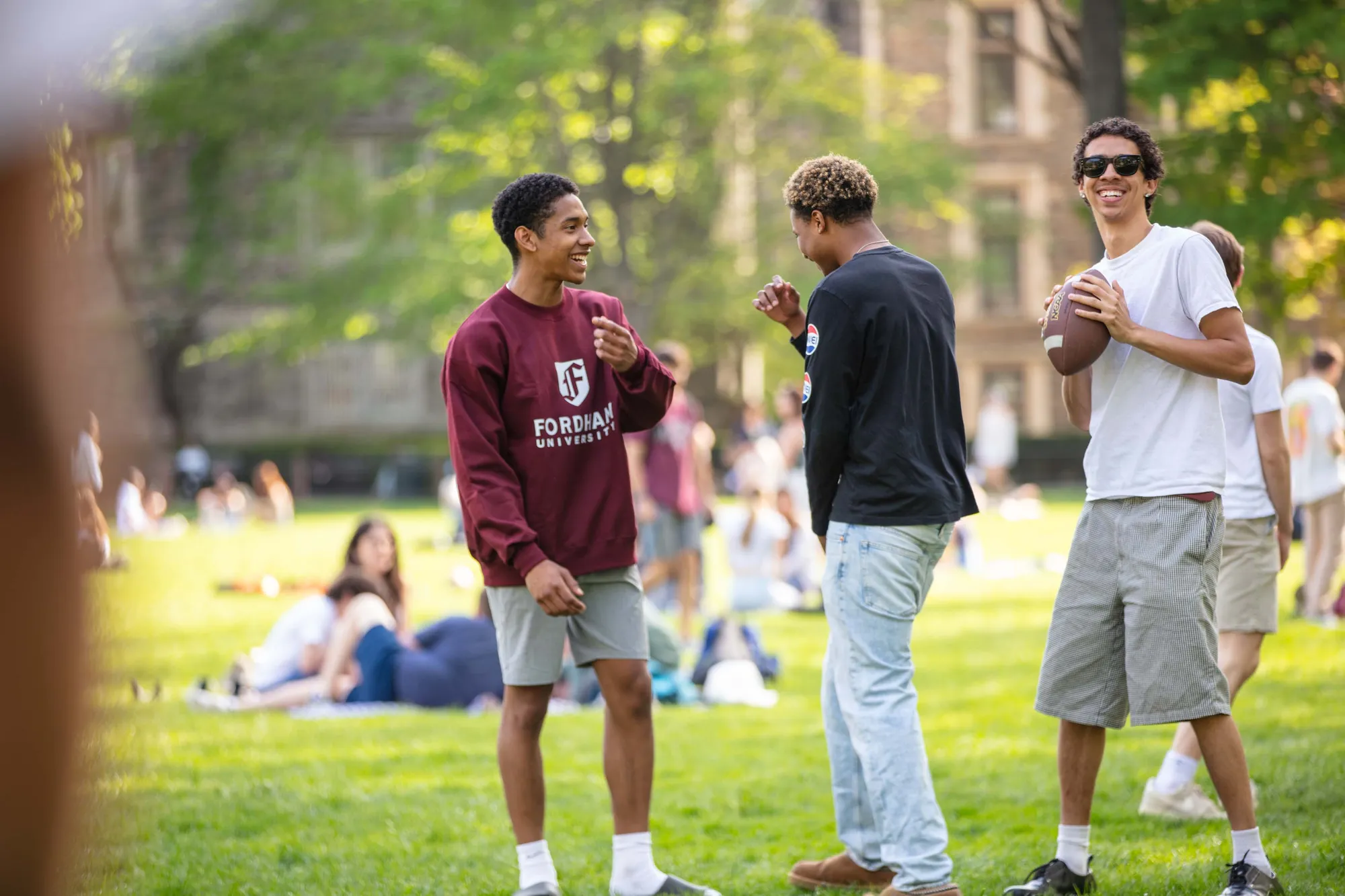 Students with a football on Eddies Parade