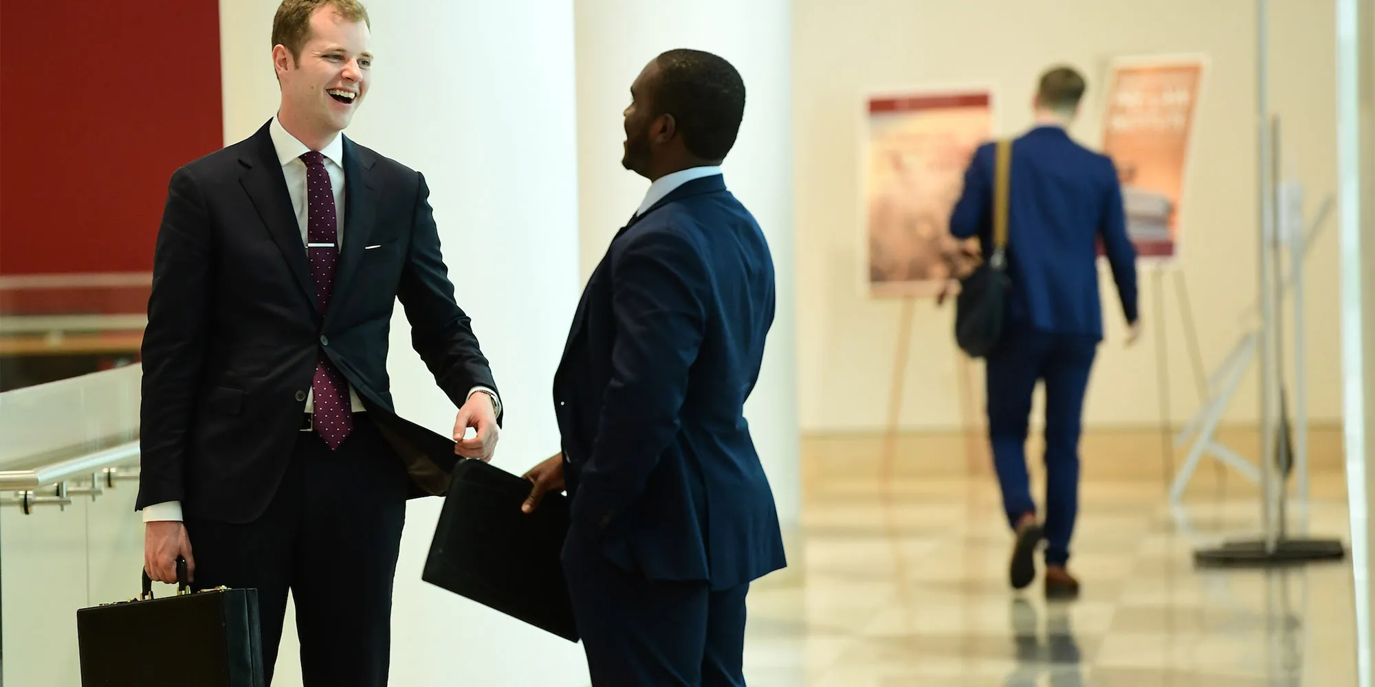 two male students in business suits 2000Wx1000H