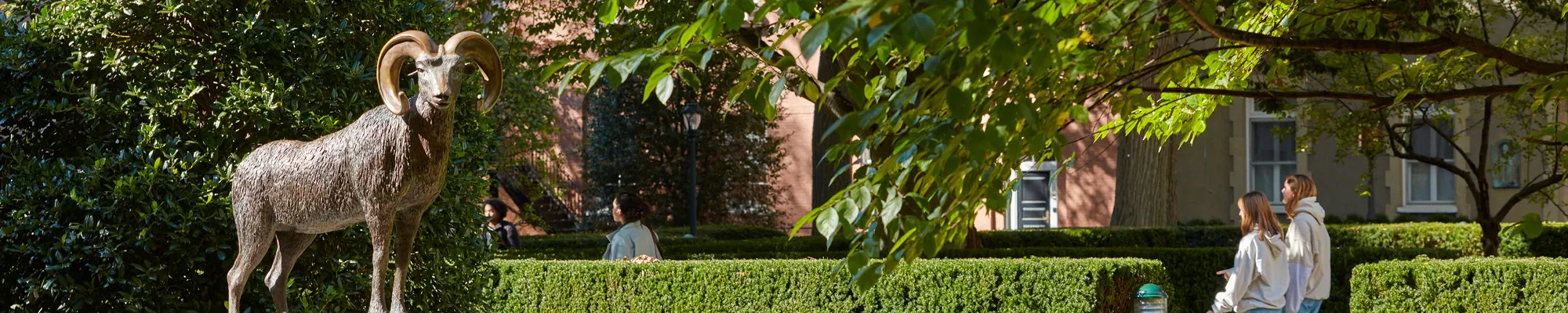 Fordham Rose Hill Students Walking By and Sitting Around the Ram Statue.