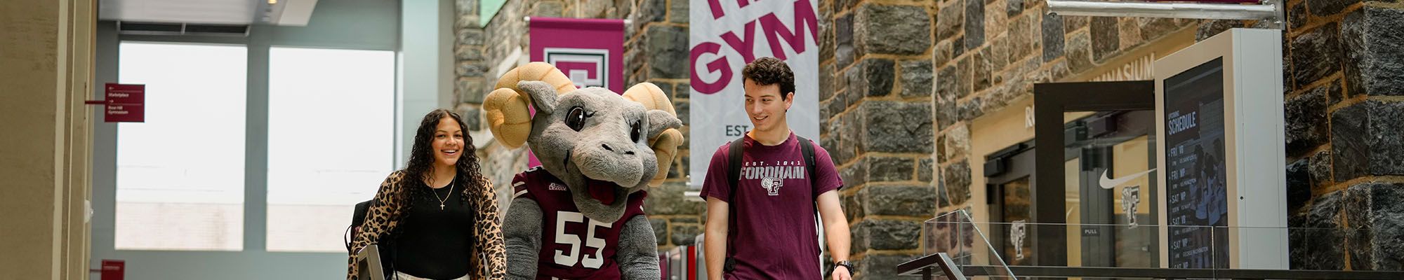 The Fordham Ram with two students on the Rose Hill campus