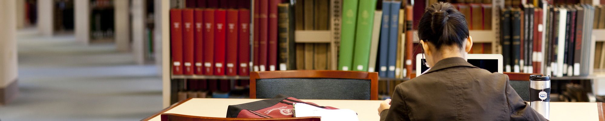 Female student studying in the library stacks