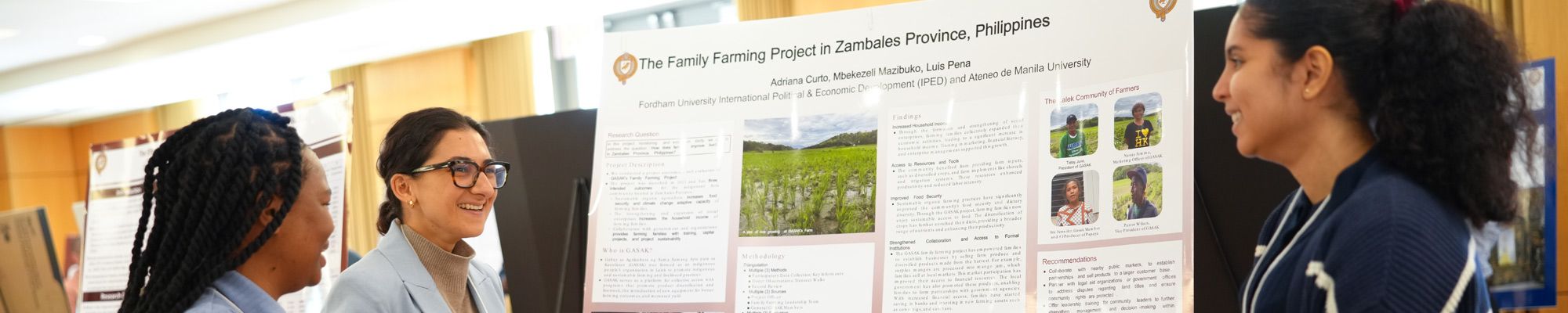Two female students present their work at a poster session