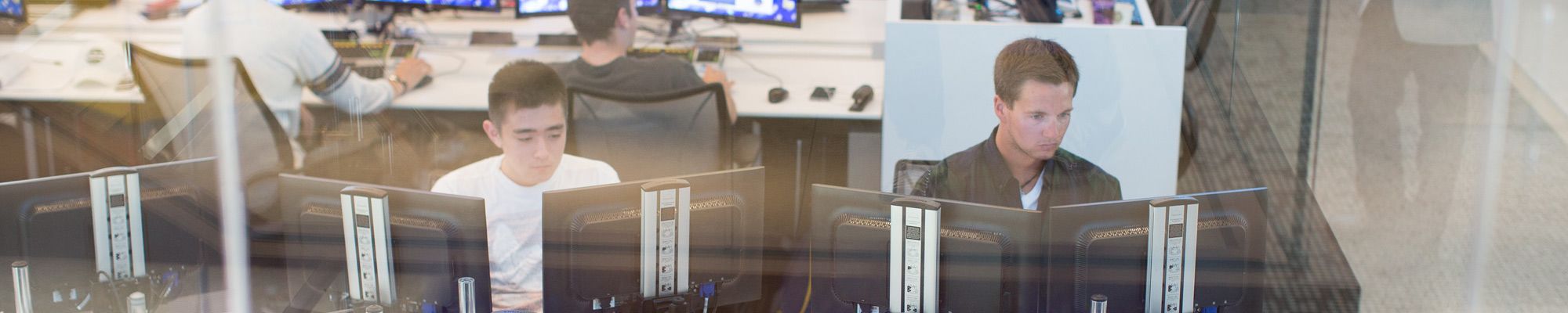 Two student working at computer terminals in a lab on campus